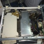 Interiorul unui aparat electrocasnic cu componente vizibile, inclusiv un motor și circuite electrice.