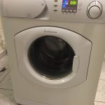 Mașină de spălat Ariston albă cu panou de control digital și ușă transparentă.