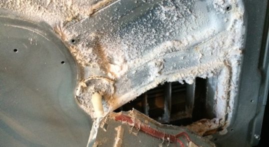 Componentă electronică cu praf și deteriorări vizibile, parte a unui aparat electrocasnic.